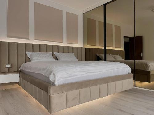 - une chambre avec un grand lit et un miroir dans l'établissement Ellie Apartment, à Cluj-Napoca