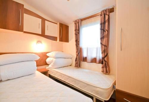 een kleine kamer met 2 bedden en een raam bij KINSGATE 2 in Shanklin