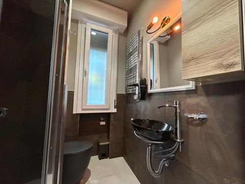 baño con lavabo y aseo y ventana en Appartamento Conchiglia-Immobili e Soluzioni Rent, en Lido Adriano