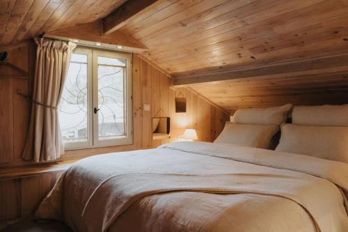 een slaapkamer met een groot bed en een raam bij refuges in Beauraing
