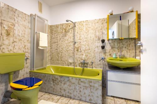 ein Badezimmer mit einer gelben Badewanne und einem Waschbecken in der Unterkunft Sonnendeck 1 in Bad Arolsen