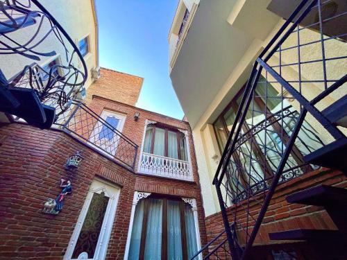 a brick building with a staircase and a balcony at Silver 34 Boutique in Tbilisi City