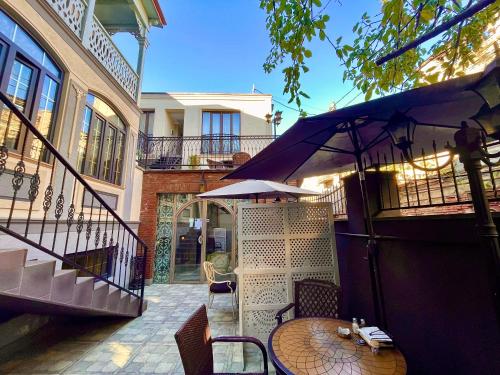 a patio with a table and an umbrella at Silver 34 Boutique in Tbilisi City
