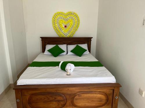 Una cama con sábanas verdes y blancas y un corazón en la pared en Greenpath at Airport reach 