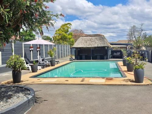 a swimming pool in a yard with a gazebo at Mino Guest House in Pietermaritzburg