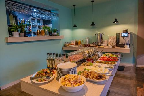 a buffet with many plates of food on a table at Hotel Mazowiecki Łódź in Łódź