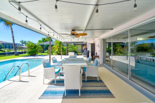 un patio al aire libre con mesa y sillas junto a una piscina en Cozy 60's home, city & canal located, en Cabo Coral
