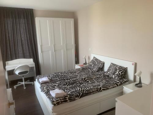 um quarto branco com uma cama com lençóis pretos e brancos em Cherkovna N em Sófia