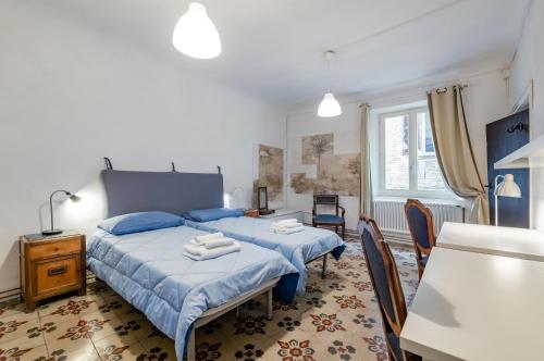 una camera da letto con due letti, un tavolo e delle sedie di Appartamento Valbona nel cuore di Urbino a Urbino