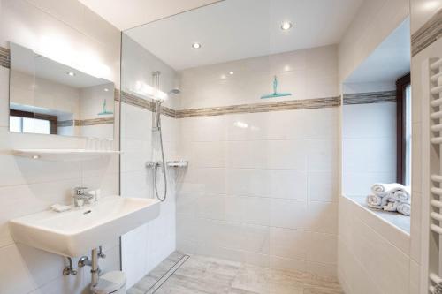 y baño blanco con lavabo y ducha. en Ferienhaus zur Hackenschmiede, en Mauterndorf