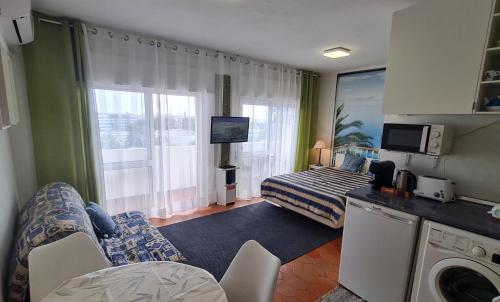 クアルテイラにあるMusa Marのベッドとリビングルームが備わるホテルルームです。