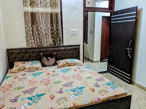 a bedroom with a bed with a floral comforter at Manu Villa A Royal Stay in Jaipur