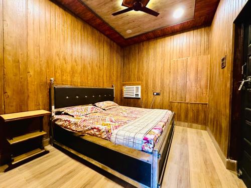 a bedroom with a bed with a ceiling fan at Vaaranya- The Woodhouse in Varanasi