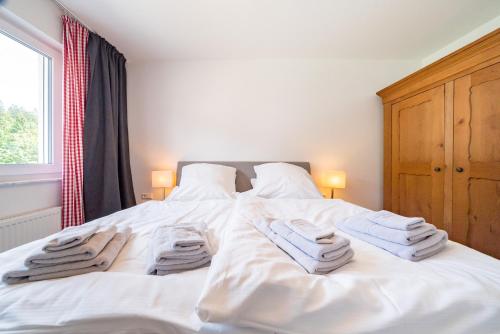 a bedroom with a white bed with towels on it at Auerhahn Feldberg in Feldberg