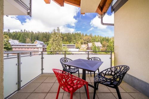 a table and chairs on a balcony with a view at Auerhahn Feldberg in Feldberg