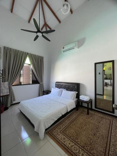 1 dormitorio con 1 cama y ventilador de techo en Traditional Melaka Homestay with Private Pool en Kampong Bukit Katil