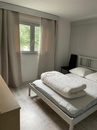 a white bedroom with a bed and a window at ST LARY SOULAN in Saint-Lary-Soulan