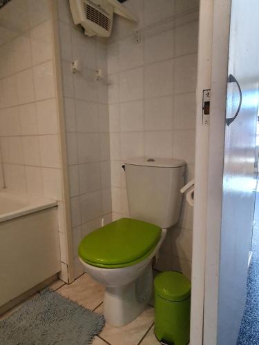 een badkamer met een toilet en een groene stoel bij 34 Roche Blanche in Val Thorens