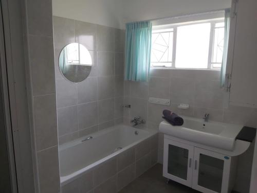 a white bathroom with a tub and a sink at Resting Place @ 89 in Bloemfontein