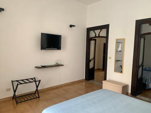 a bedroom with a bed and a tv on the wall at Isola delle Femmine Apartment in Capaci in Capaci