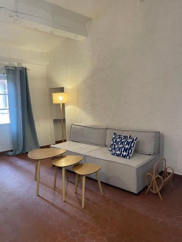 un salon avec un canapé et deux tables dans l'établissement Maison de village sur Bormes les Mimosas, à Bormes-les-Mimosas