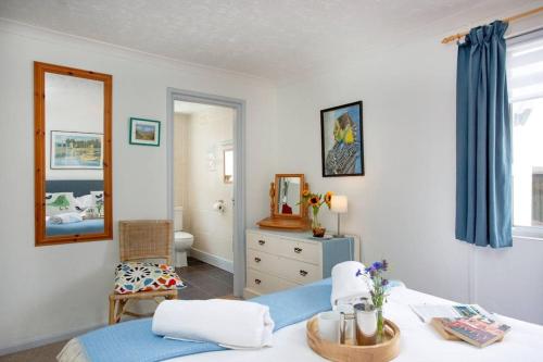 - une chambre avec un lit et un miroir dans l'établissement Orchard Cottage, à Sidmouth