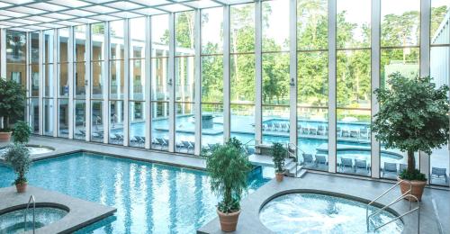 an indoor swimming pool in a building with windows at Victoria Suites in Bad Saarow