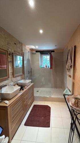une grande salle de bain avec deux lavabos et une douche dans l'établissement La Maillardière - Maison de campagne avec piscine, à Corné