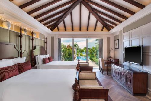 um quarto com uma cama grande e uma televisão em JW Marriott Sanya Haitang Bay Resort & Spa em Sanya