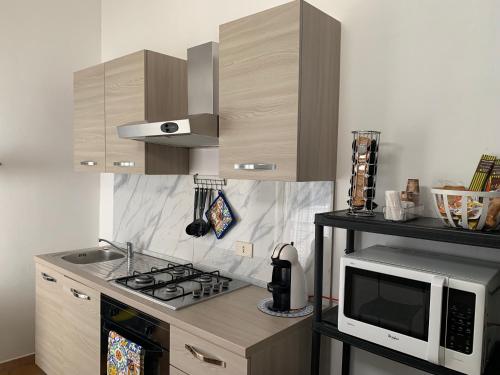 a kitchen with a microwave and a stove top oven at Isola delle Femmine Apartment in Capaci in Capaci
