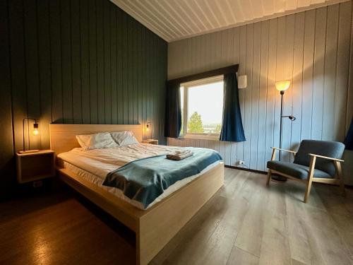 um quarto com uma cama, uma cadeira e uma janela em Morgedal Gjestehus em Morgedal