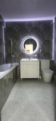 a bathroom with a sink and a toilet and a mirror at Квартира со всеми удобствами in Osh