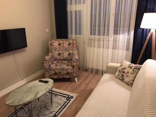 uma sala de estar com um sofá e uma cadeira em The Rooms Boutique Otel em Kumbağ