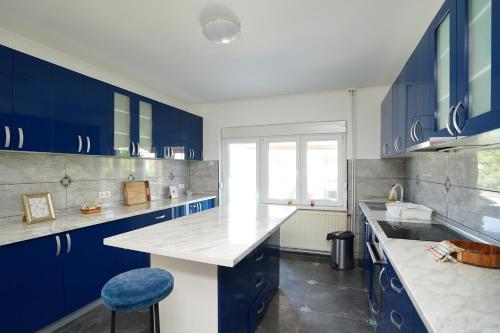 a kitchen with blue cabinets and a white counter top at Kuća za odmor DUNJA in Kladovo