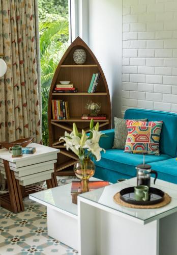 a living room with a blue couch and a table at El Rocio Estate 2bhk in Assagao with Common pool, Free Parking,8 min away from Vagator in Assagao