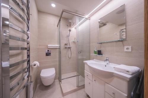 a bathroom with a shower and a sink and a toilet at Gynėjų Self Check-in Apartments - Lollo Stay in Vilnius