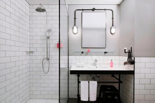 a white bathroom with a sink and a mirror at MOXY Bandung in Bandung