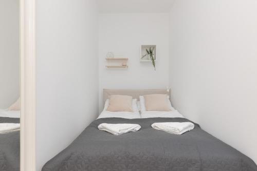 een slaapkamer met een bed met 2 kussens erop bij Spacious & Comfortable Studio Apartament Rajska with Balcony by Renters in Łódź