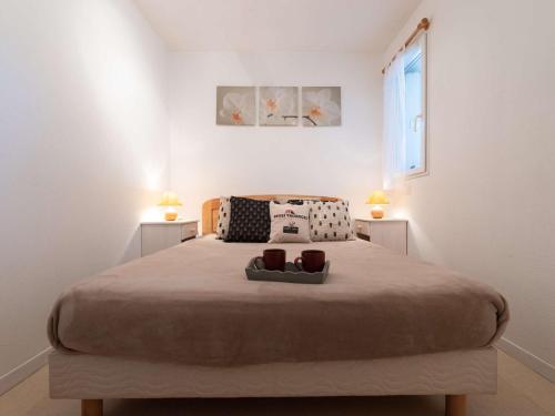 une chambre avec un grand lit avec deux lampes dans l'établissement Appartement cosy 6 pers, Saint-Lary village, Quartier Thermal, télécabine proche - FR-1-296-136, à Saint-Lary-Soulan