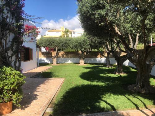 a garden with trees and a building in the background at Chalet individual con jardín en Puerto Rey, Vera in Los Amarguillos