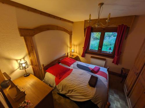 een slaapkamer met een bed, een bureau en een raam bij le jardin de talèfre in Chamonix-Mont-Blanc