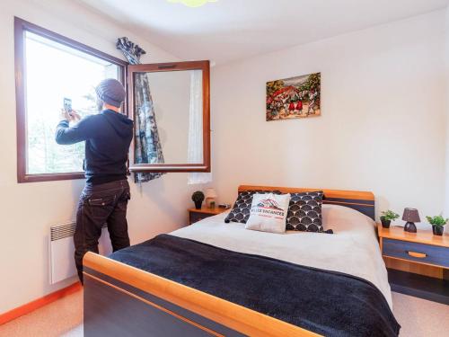 un hombre está tomando una foto de la ventana de un dormitorio en Appartement Saint-Lary-Soulan, 3 pièces, 6 personnes - FR-1-296-143 en Saint-Lary-Soulan