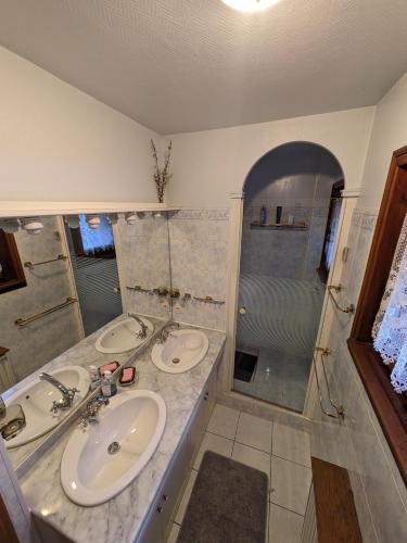 une salle de bain avec deux lavabos et une douche dans l'établissement le jardin de talèfre, à Chamonix-Mont-Blanc