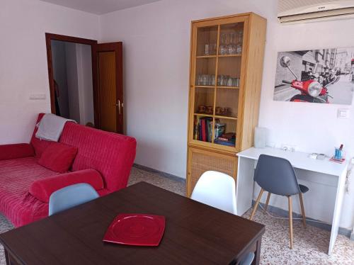 een woonkamer met een rode bank en een tafel bij Plein centre, proche plage et port, garage in Águilas