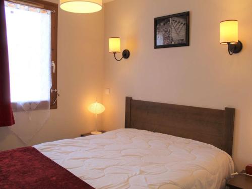 une chambre avec un lit avec deux lampes et une fenêtre dans l'établissement Charmant T2 avec piscine, parking privé et accès direct aux pistes à Vars Les Claux - FR-1-330B-176, à Vars