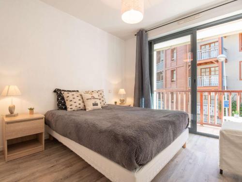 ein Schlafzimmer mit einem großen Bett und einem großen Fenster in der Unterkunft Appartement 6 pers. Saint Lary - Centre, Garage, WiFi - FR-1-296-361 in Saint-Lary-Soulan