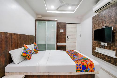 um quarto com uma cama e uma televisão na parede em FabHotel Krishna Inn em Bhiwandi