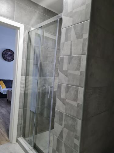 um chuveiro com uma porta de vidro na casa de banho em KARIBO apartman 3 em Sombor
