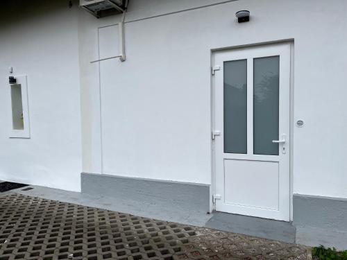 a white door on the side of a white building at Mezonet Svítkov 21 in Pardubice