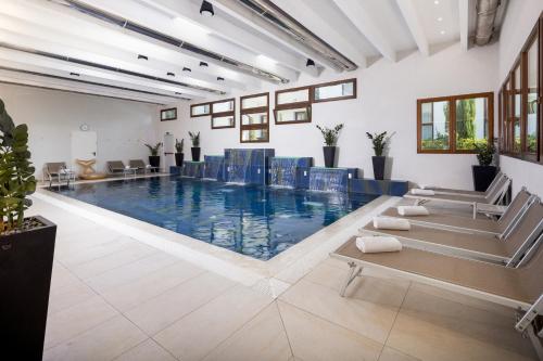una gran piscina con sillas azules en un edificio en Best Western Modena District, en Campogalliano